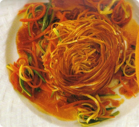 Nidi di tagliolini fritti con verdure miste.